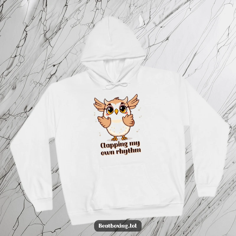Funny hoodie featuring a surprised owl character clapping its wings in time with a beat, radiating a happy, musical vibe.